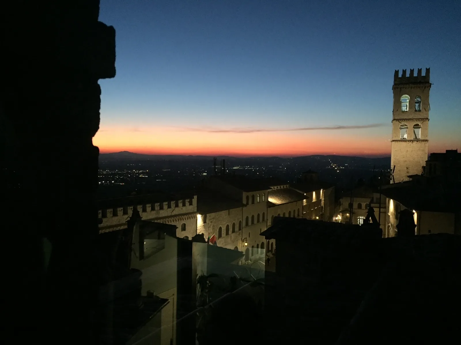 A hilltop town at dusk with its tower against the evening sky