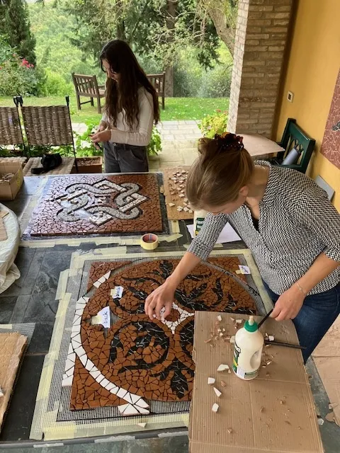 Guests laying tesserae on a mosaic panel on the terrace